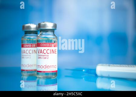 Charkow, Ukraine - 3. November 2021: Impfstoff gegen Moderna COVID-19. Coronavirus-Impffläschchen mit Spritze auf Glastisch im Krankenhaus-Hintergrundbild Stockfoto