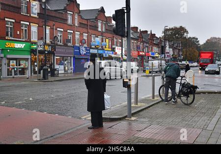 Orthodoxer jüdischer Mann, der die in Cheetham Hill, Greater Manchester, Lancashire, Großbritannien, überquert Stockfoto