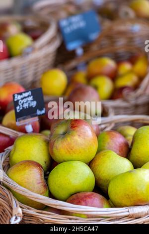 Frisch gepflückte Äpfel in Korbkörben auf dem Bauernmarkt Obst- und Gemüsestände, frische rosige rote und grüne Äpfel auf einem Obststand Stockfoto