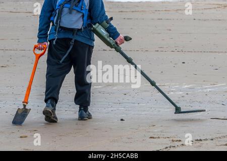 Metalldetektor, Metalldetektor, Metalldetektor, Mann mit Metalldetektor, Mann mit Metalldetektor am Strand, Mann auf Schatzsuche mit Spaten. Stockfoto