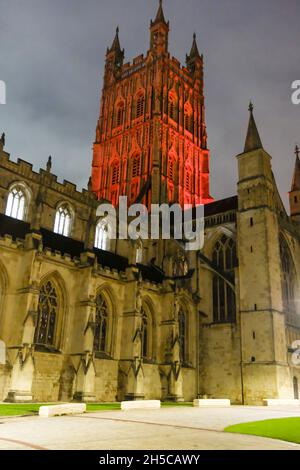 Gloucester, Großbritannien. November 2021. Der Turm der Gloucester Cathedral wurde als ein Akt der Erinnerung mit roten Lichtern beleuchtet. Der Turm aus dem 15. Jahrhundert ist ein zentraler Punkt für Menschen, die sich an diejenigen erinnern, die in früheren Konflikten ihr Leben gegeben haben. Kredit: JMF Nachrichten/Alamy Live Nachrichten Stockfoto