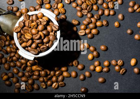 Gemahlener Kaffee in einem Horn zwischen aromatischen Bohnen. Konzept für die Zubereitung von Hauskaffee. Horizontale Ausrichtung. Draufsicht. Nahaufnahme. Stockfoto