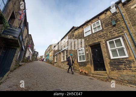 Haworth ist ein Touristenziel, das für seine Verbindung mit den Schwestern von Brontë und das erhaltene Erbe Keighley und Worth Valley Railway bekannt ist. Das Dorf liegt in den Pennine Hills von West Yorkshire in Großbritannien und ist bekannt für seine steile Kopfsteinpflasterstraße. Stockfoto