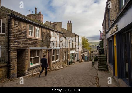 Haworth ist ein Touristenziel, das für seine Verbindung mit den Schwestern von Brontë und das erhaltene Erbe Keighley und Worth Valley Railway bekannt ist. Das Dorf liegt in den Pennine Hills von West Yorkshire in Großbritannien und ist bekannt für seine steile Kopfsteinpflasterstraße. Stockfoto