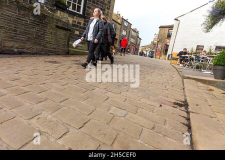 Haworth ist ein Touristenziel, das für seine Verbindung mit den Schwestern von Brontë und das erhaltene Erbe Keighley und Worth Valley Railway bekannt ist. Das Dorf liegt in den Pennine Hills von West Yorkshire in Großbritannien und ist bekannt für seine steile Kopfsteinpflasterstraße. Stockfoto