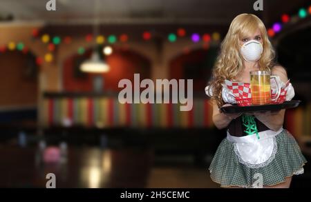 Kellnerin mit N95 Maske halten Bierbecher, flache DOF Fokus auf Bier Stockfoto