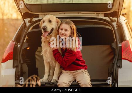 Mädchen mit goldenem Retriever Hund im Auto Stockfoto