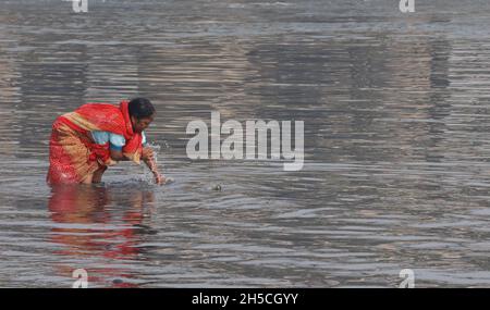 Neu-Delhi, Indien. November 2021. Eine Anhängerin nimmt ein Bad, bevor sie an einem rauchigen Morgen in Neu-Delhi am Ufer des Holly River Yamuna ihre Gebete darbringt. (Foto von Naveen Sharma/SOPA Images/Sipa USA) Quelle: SIPA USA/Alamy Live News Stockfoto