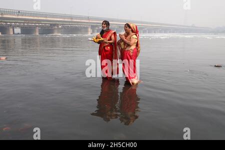 Neu-Delhi, Indien. November 2021. Eifrige Anhänger beten an einem rauchigen Morgen in Neu-Delhi im Rahmen des bevorstehenden Hindu-Festivals Chhat Puja am Ufer des Stechenflusses Yamuna vor gott. (Foto von Naveen Sharma/SOPA Images/Sipa USA) Quelle: SIPA USA/Alamy Live News Stockfoto