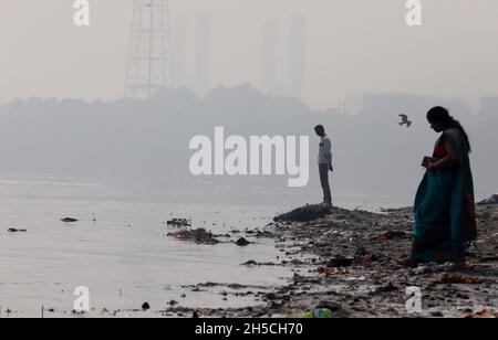 Neu-Delhi, Indien. November 2021. Eifrige Anhänger besuchen das Ufer des Holly River Yamuna, um an einem rauchigen Morgen in Neu-Delhi ihre Gebete an gott im Rahmen des bevorstehenden Hindu-Festivals Chhat Puja zu richten. Kredit: SOPA Images Limited/Alamy Live Nachrichten Stockfoto