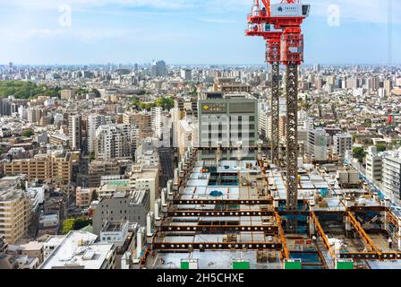 tokio, japan - Mai 03 2019: Bunkyo Garden Gate Tower im Bau mit erhöhten Kränen auf dem Wolkenkratzer und Arbeitern, die auf der Last laufen. Stockfoto