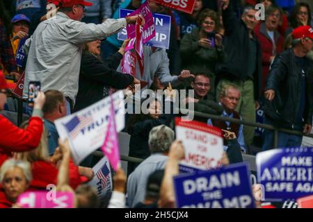 11052018 - Fort Wayne, Indiana, USA: Ein Protestler wird wegeskortiert, während der US-Präsident Donald J. Trump für die Kandidaten des US-Kongresses in Indiana kämpft, darunter Mike Braun, der für den Senat kandidieren wird, während ein Make America Great Again! Kundgebung am Allen County war Memorial Coliseum in Fort Wayne, Indiana. Stockfoto