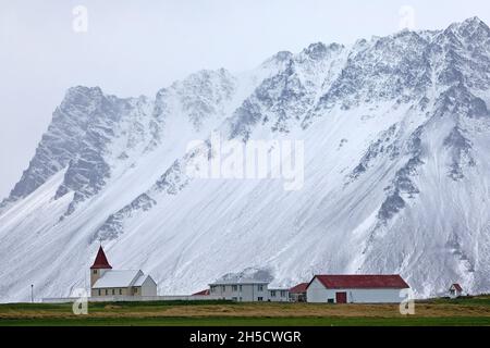Kleine Kirche mit einem Bauernhof vor schneebedeckten Snaefellsjoekull, Island, Snaefellsnes Stockfoto