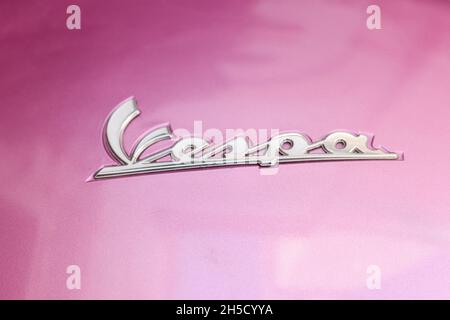 Mailand, Italien. 6. Oktober 2021: Vespa-Logo, Motorradmarke, auf rosa Hintergrund. Stockfoto