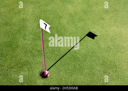 Loch mit kleiner Flagge am Minigolfplatz markiert. Nummernflagge auf einem Minigolfplatz Stockfoto