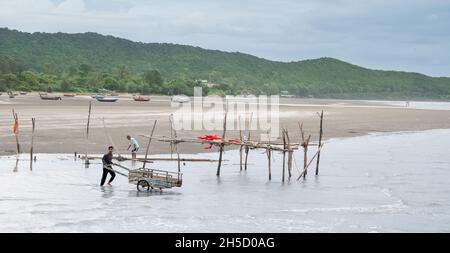 Chantaburi / THAILAND - Okt 13, 2021: Die Einheimischen ziehen den Holzkarren, um den Müll aus dem Meer und fast dem Küstenbereich zum Recycling zu sammeln. Stockfoto