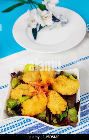 Gebratene panierte Garnelen mit Salat und Tischset. Stockfoto