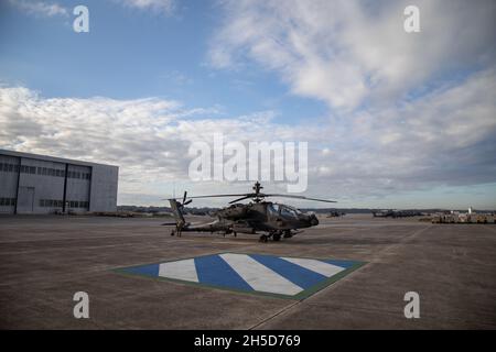 Ein AH-64E Apache-Hubschrauber der 3rd Combat Aviation Brigade sitzt vor einem Hangar im Hunter Army Airfield, Georgia, November 2. Die Soldaten der 3. Staffel, des 17. Kavallerieregiments, des 3. CAB, führten Luftgewehrschießen durch, wodurch sie ihre missionskribellen Aufgaben trainieren und gleichzeitig die Einsatzbereitschaft der Brigade verbessern konnten. (USA Armeefoto von Sgt. Andrew McNeil/3rd Combat Aviation Brigade, 3rd Infantry Division) Stockfoto