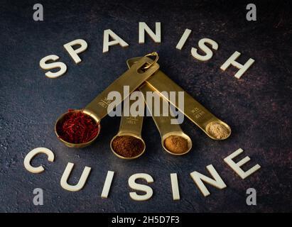 Messlöffel gefüllt mit verschiedenen Gewürzen, die in der spanischen Küche verwendet werden. Stockfoto