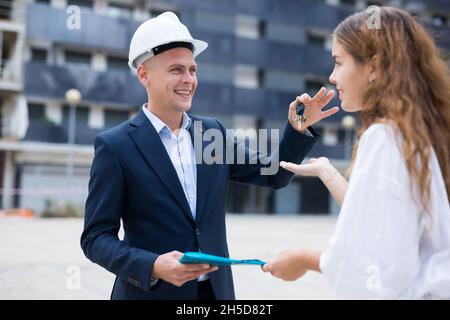 Frau, die Schlüssel vom Immobilienmanager erhält Stockfoto