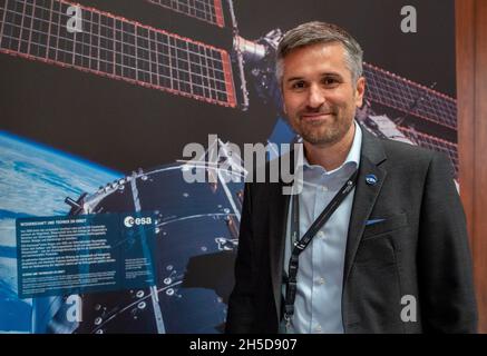 Oberthal, Deutschland. Oktober 2021. Mathias Link, Direktor der Luxemburger Weltraumorganisation LSA, steht auf der Startparty zum verschobenen Start der ISS vor einem Plakat der Raumstation. Mittlerweile haben sich 70 Unternehmen und Forschungsinstitute rund um das Thema Raumfahrt in Luxemburg niedergelassen, sagt Link. (Zum dpa-Text: Luxemburg konzentriert sich auf die Nutzung von Weltraumressourcen) Quelle: Harald Tittel/dpa/Alamy Live News Stockfoto