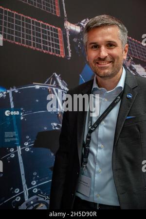 Oberthal, Deutschland. Oktober 2021. Mathias Link, Direktor der Luxemburger Weltraumorganisation LSA, steht auf der Startparty zum verschobenen Start der ISS vor einem Plakat der Raumstation. Mittlerweile haben sich 70 Unternehmen und Forschungsinstitute rund um das Thema Raumfahrt in Luxemburg niedergelassen, sagt Link. (Zum dpa-Text: Luxemburg konzentriert sich auf die Nutzung von Weltraumressourcen) Quelle: Harald Tittel/dpa/Alamy Live News Stockfoto
