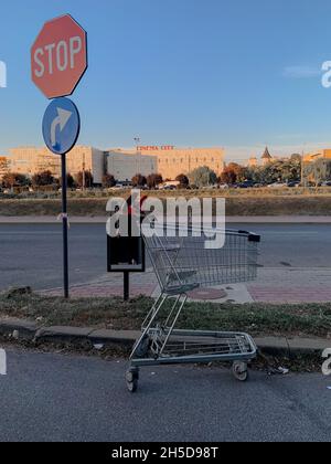 Nahaufnahme eines verlassenen Einkaufswagens in der Straße unter DEM STOPPSCHILD Stockfoto