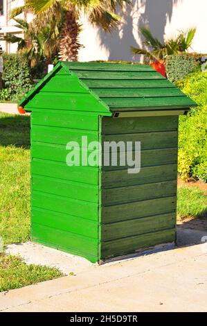 3D-Rendering vertikales Format eines grünen hölzernen Hundehauses im Garten eines Hauses Stockfoto