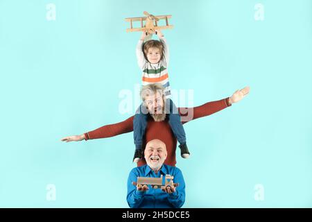 Drei verschiedene Generationen alt Großvater Vater und Kind Sohn spielen mit Spielzeug Flugzeug im Studio. Journey Reise Reisekonzept. Isolierter Hintergrund Stockfoto