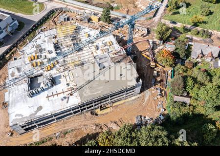 Bauherren Gießen nassen Beton, mit Schlauch aus Beton Pumpmaschine in Bodenplatte Form. Luftaufnahme der Baustelle. Stockfoto