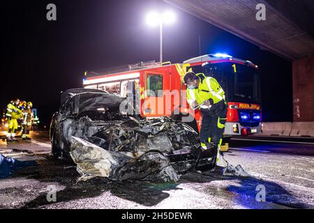 Garbsen, Deutschland. November 2021. Auf der Autobahn 2 bei Hannover steht ein ausgebranntes Autowrack - ein Unfallforscher untersucht die Szene. Bei dem Verkehrsunfall wurde eine Frau in ihrem Fahrzeug zu Tode verbrannt, nachdem sie auf einen Lastwagen gestoßen war und ihr Auto in Brand gesteckt hatte. Quelle: Moritz Frankenberg/dpa/Alamy Live News Stockfoto