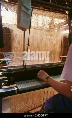 Laos: Webstuhl und Weber bei Lao Textiles, Vientiane. Lao Textiles ist ein Showroom und Webstudio mit Sitz in Vientiane, Laos. Das Unternehmen wurde 1990 von der Amerikanerin Carol Cassidy gegründet und produziert eine breite Palette von handgewebten Seidentextilien, darunter Brokat, Wandteppiche und Gardinenstoffe. Stockfoto