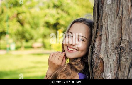 Immer lächelnd. Glückliches Mädchen lächeln am Baum auf der Sommerlandschaft. Zahngesundheit. Mundpflegeprodukte. Zahnpflege. Kinderzahnmedizin. Mundhygiene beachten Stockfoto