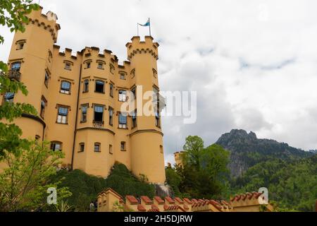 26. Mai 2019 Füssen, Deutschland - Schloss Hohenschwangau inmitten grüner alpiner Frühjahrsberge. Stockfoto