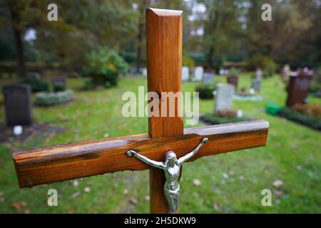 Hamburg, Deutschland. November 2021. Ein Kruzifix und Gräber sind auf dem Ohlsdorfer Friedhof zu sehen. Kredit: Marcus Brandt/dpa/Alamy Live Nachrichten Stockfoto