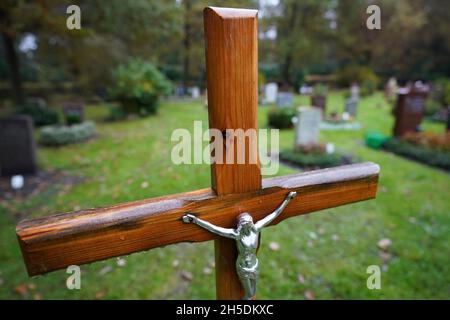 Hamburg, Deutschland. November 2021. Ein Kruzifix und Gräber sind auf dem Ohlsdorfer Friedhof zu sehen. Kredit: Marcus Brandt/dpa/Alamy Live Nachrichten Stockfoto