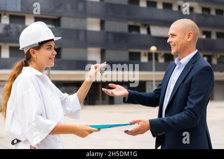 Mann, der Schlüssel zur Wohnung vom Immobilienmanager erhält Stockfoto
