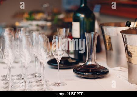 Der Kellner gießt erlesenen Rotwein in die Dekanter auf dem Tisch im Restaurant. Stockfoto