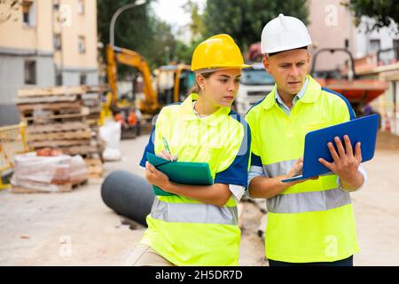 Zwei Architekten mit Laptop diskutieren über den Bauplan Stockfoto