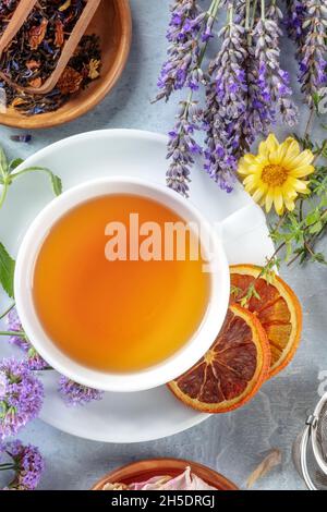 Tee. Kräuter, Blumen und Früchte, von oben mit einer Tasse Tee geschossen, eine flache Laie mit trockener Orange und Lavendel Stockfoto