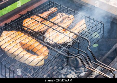 Frische Lachs Fisch Steaks auf dem Grill. Das Konzept der Küche auf der Straße, Hinterhof Stockfoto