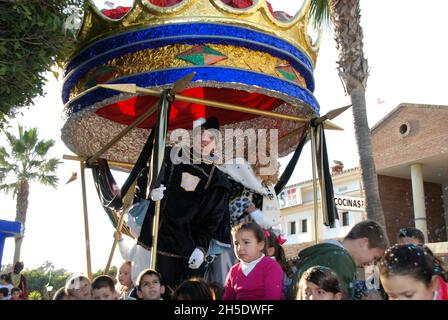 Parade der drei Könige mit Gaspar in seiner Kutsche und Kindern, die auf dem Festwagen sitzen, La Cala de Mijas, Spanien Stockfoto