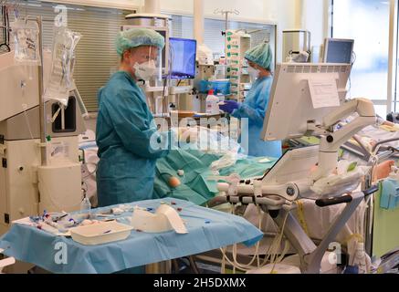 Leipzig, Deutschland. November 2021. Ärzte und Krankenschwestern betreuen einen Patienten auf der Covid-Station, einem Bereich der operativen Intensivstation des Universitätsklinikums Leipzig. Auf der Intensivstation wächst seit Tagen die Zahl der Corona-Patienten mit schweren Verläufen, darunter immer mehr jüngere Patienten im Alter zwischen 30 und 60 Jahren. Quelle: Waltraud Grubitzsch/dpa-Zentralbild/dpa/Alamy Live News Stockfoto