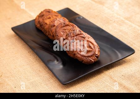 Süßes Dessert Indischer Mithai Thekua Oder Khajur Aus Weizenmehl Aata Shuddha Desi Kuhbutter Ghee Gur In Schwarzem Tablett Auf Traditionellem Braunen Khaki-Burlap Stockfoto