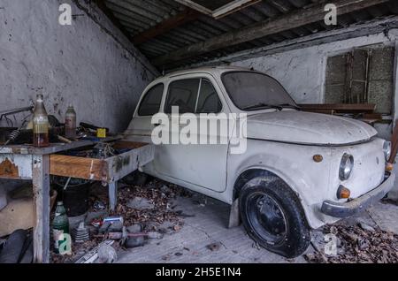 Kleines Auto in einer verlassenen Garage Stockfoto