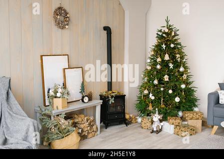 Gemütliches weihnachtszimmer mit Inneneinrichtung. Rustikales Wohndesign für warme Innenräume. Modernes Wohnzimmer mit Holzwand und Möbeln. Scandina Stockfoto