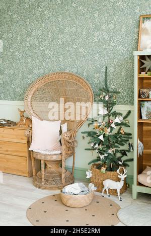 Vintage Korbsessel in der Nähe des Weihnachtsbaums im Kinderzimmer Stockfoto