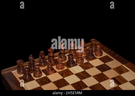 Holzschachbrett auf schwarzem Hintergrund Stockfoto