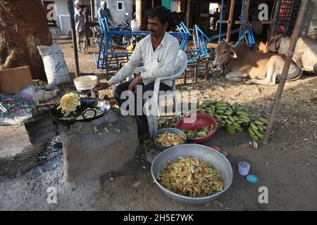 29. April 2016, Maharashtra, Indien. Mann am Straßenrand frittiert rohe Bananen in Öl zu Waffeln Stockfoto