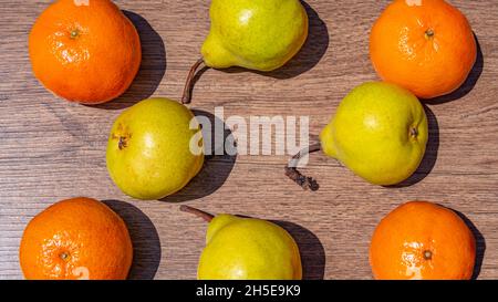Nahaufnahme von Birnen und Mandarinen auf einer hölzernen Oberfläche Stockfoto